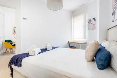 a white bedroom with a large bed with towels on it at R&C APARTMENTS CLOSE to CENTER in Valencia