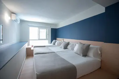 a bedroom with two beds with a blue wall at Olympia Consul del Mar in Valencia