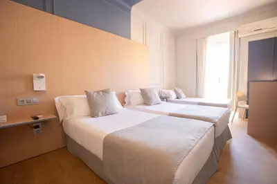 a hotel room with two beds and a window at Olympia Consul del Mar in Valencia