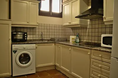 a kitchen with a washing machine and a microwave at Castillo con piscina en plena Sierra Calderona in Segorbe