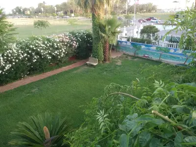 a yard with a park with a bench and flowers at Apartamento con terraza y vistas al mar in Burriana