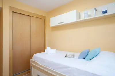 a bedroom with a white bed with blue pillows at SingularStays Moncofar Beach in Moncófar
