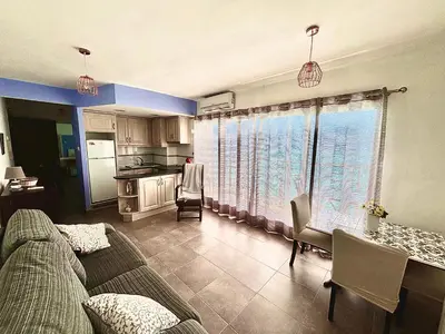 a living room with a couch and a table and a kitchen at Faro de Cullera I in Faro de Cullera
