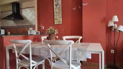 a dining room with red walls and a table and chairs at La Media Luna in Segorbe