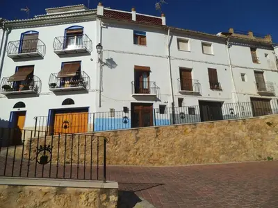 a white building with balconies and a fence at La Media Luna in Segorbe