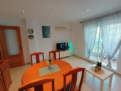 a dining room with a table and chairs and a television at Seabreeze Lighthouse Apartment in Faro de Cullera