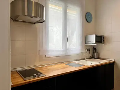 a kitchen with a sink and a microwave and a window at Maritime Apartamentos Cabañal in Valencia