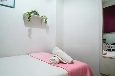 a white room with a bed with a towel on it at Ruzafa Apartment in Valencia