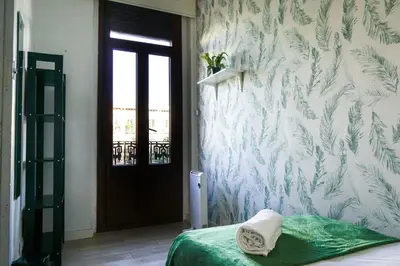 a bedroom with a bed and a wall with plants at Ruzafa Apartment in Valencia
