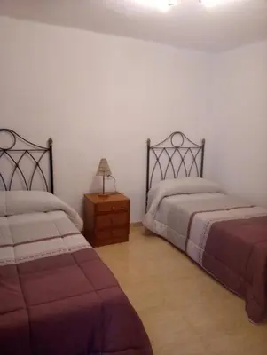 a bedroom with two beds and a table with a lamp at Ca Michico in Tous