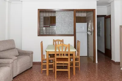 a kitchen and dining room with a table and chairs at ROS MARY, 7º-14 in Cullera