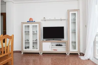 a living room with a tv and a white cabinet at ROS MARY, 7º-14 in Cullera