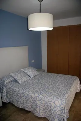a bedroom with a bed with a blue wall at Holiday Apartments Malvarrosa Beach in Valencia