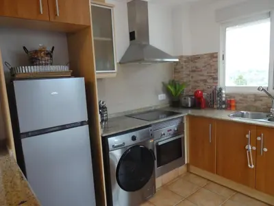 a kitchen with a white refrigerator and a dishwasher at LAS PALOMAS, appartement 3 chambres avec piscine in Turís