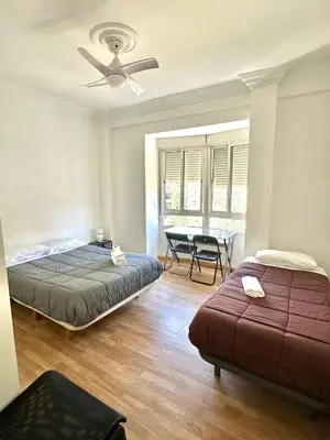 a bed in the corner of a room with a window at Rooms Valencia Center in Valencia