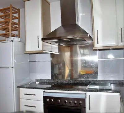 a kitchen with white cabinets and a stove top oven at Apartamento Playa Moncofar - Xilxes in Moncófar