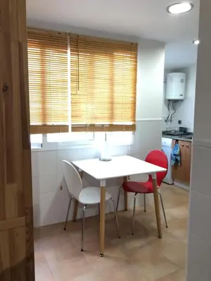 a table and chairs in a kitchen with a window at 150 Playa in Puerto de Sagunto