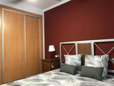 a bedroom with a large bed and a red wall at 150 Playa in Puerto de Sagunto
