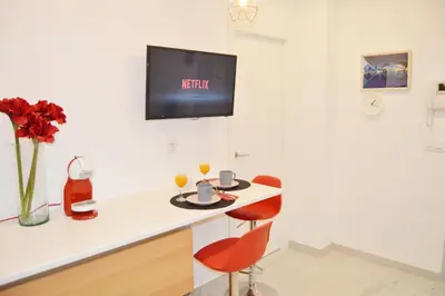 a room with a table with two chairs and a tv on the wall at COZY & MODERN Apartment junto a Metro A Guimerá in Valencia