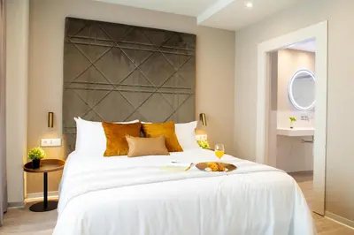 a bedroom with a large white bed with a large headboard at Voghe Premium Flats in Valencia
