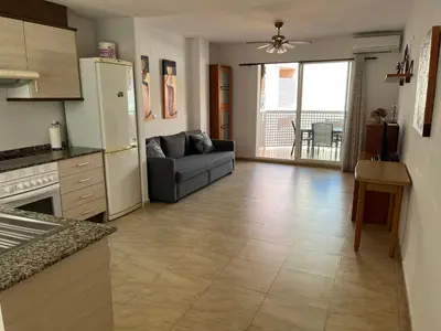 a kitchen and living room with a couch and a refrigerator at Apartamento Playa Grau Moncofa in Moncófar