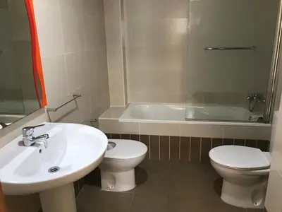 a bathroom with a sink and a toilet and a tub at Apartamento Playa Grau Moncofa in Moncófar