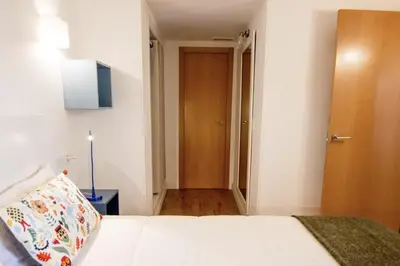 a bedroom with a white bed and a wooden door at Central Station. Free Wifi & Terrace in Valencia