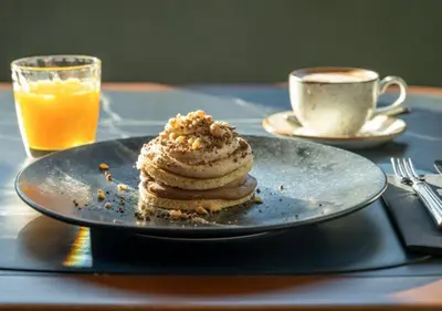 a plate with a stack of pancakes and a cup of coffee at Only YOU Hotel Valencia in Valencia