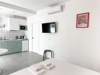 a white kitchen with a bed in a room at Apartamentos Navío in Valencia