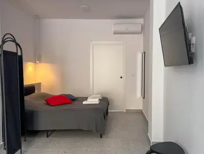 a small bedroom with a bed with a tv on the wall at Apartamentos Navío in Valencia