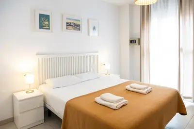 a white bedroom with two towels on a bed at Hideout 26 in Valencia