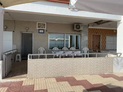 a patio with a table and chairs on a house at Broadway es Mar in El Perelló