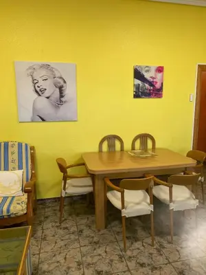 a dining room with a wooden table and chairs at Broadway es Mar in El Perelló