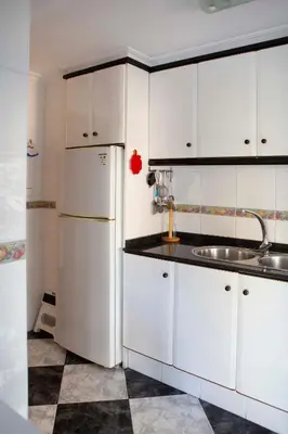 a kitchen with a white refrigerator and a sink at Bonito apartament a 3 minutos de la playa in Cullera