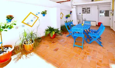 a patio with blue tables and chairs and potted plants at Emma Apartment Central in Valencia