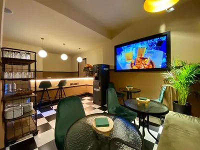 a living room with tables and chairs and a flat screen tv at Hografic Hotel in Valencia