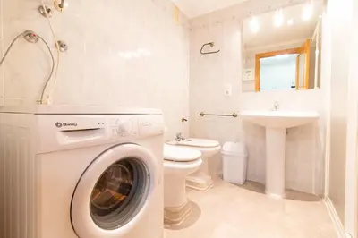 a washing machine in a bathroom with a toilet and a sink at Global Vacacional, Apartamento 2 dormitorios en Canet d'en Berenguer in Canet de Berenguer
