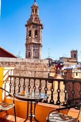 a table and chairs on a balcony with a clock tower at Happy Apartments Valencia – Lope de Vega in Valencia