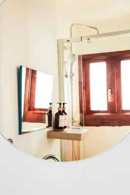 a bathroom with a round mirror and a sink at Happy Apartments Valencia – Lope de Vega in Valencia