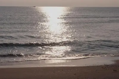 a beach with the sun reflecting on the water at Beachfront House, Valencia, Wifi, Paddle Surf Board, Incredible Views in Sueca