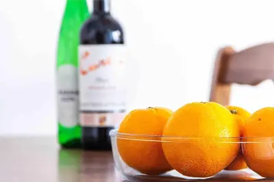 a bowl of oranges on a table with a bottle of wine at Acogedor Dúplex con terraza interior en la playa in Valencia