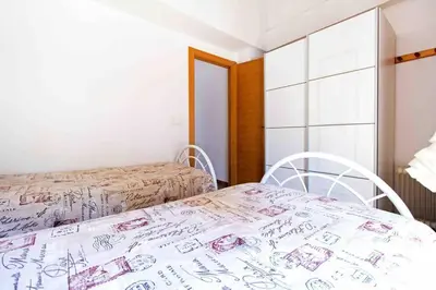 a bedroom with two beds and a table and chairs at Acogedor Dúplex con terraza interior en la playa in Valencia