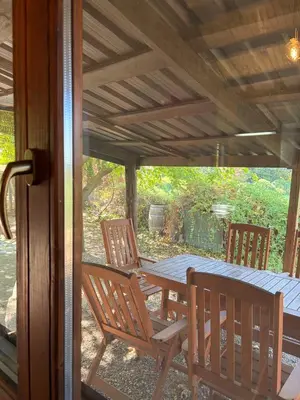 a porch with a wooden table and chairs on a patio at Pago de Tharsys in Requena