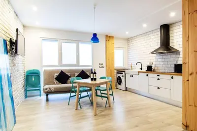 a kitchen and living room with a table and a couch at Chic y renovado loft en la playa in Valencia
