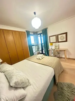 a bedroom with a large bed with a blue headboard at Marin Beach Apartments Patacona in Valencia