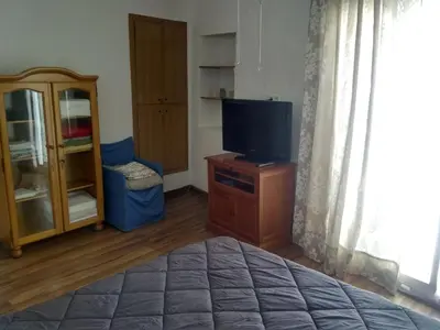 a bedroom with a bed and a tv and a cabinet at Casa Blanca in Algimia de Alfara