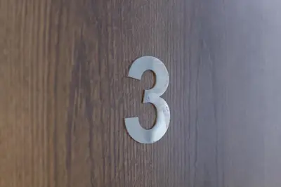 a metal number three on a wooden door at A Casa Martínez B&B in Valencia