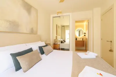 a bedroom with a large white bed with blue pillows at Encantador apartamento junto al Mediterraneo by Hometels in Puerto de Sagunto