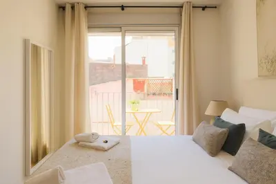 a bedroom with two beds and a view of a balcony at Encantador apartamento junto al Mediterraneo by Hometels in Puerto de Sagunto
