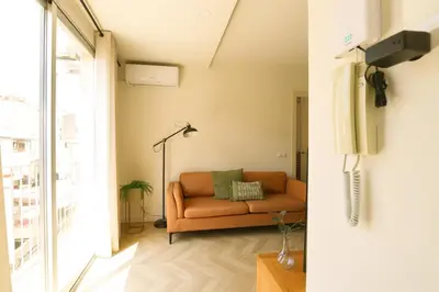a living room with a couch and a tv at Encantador apartamento junto al Mediterraneo by Hometels in Puerto de Sagunto